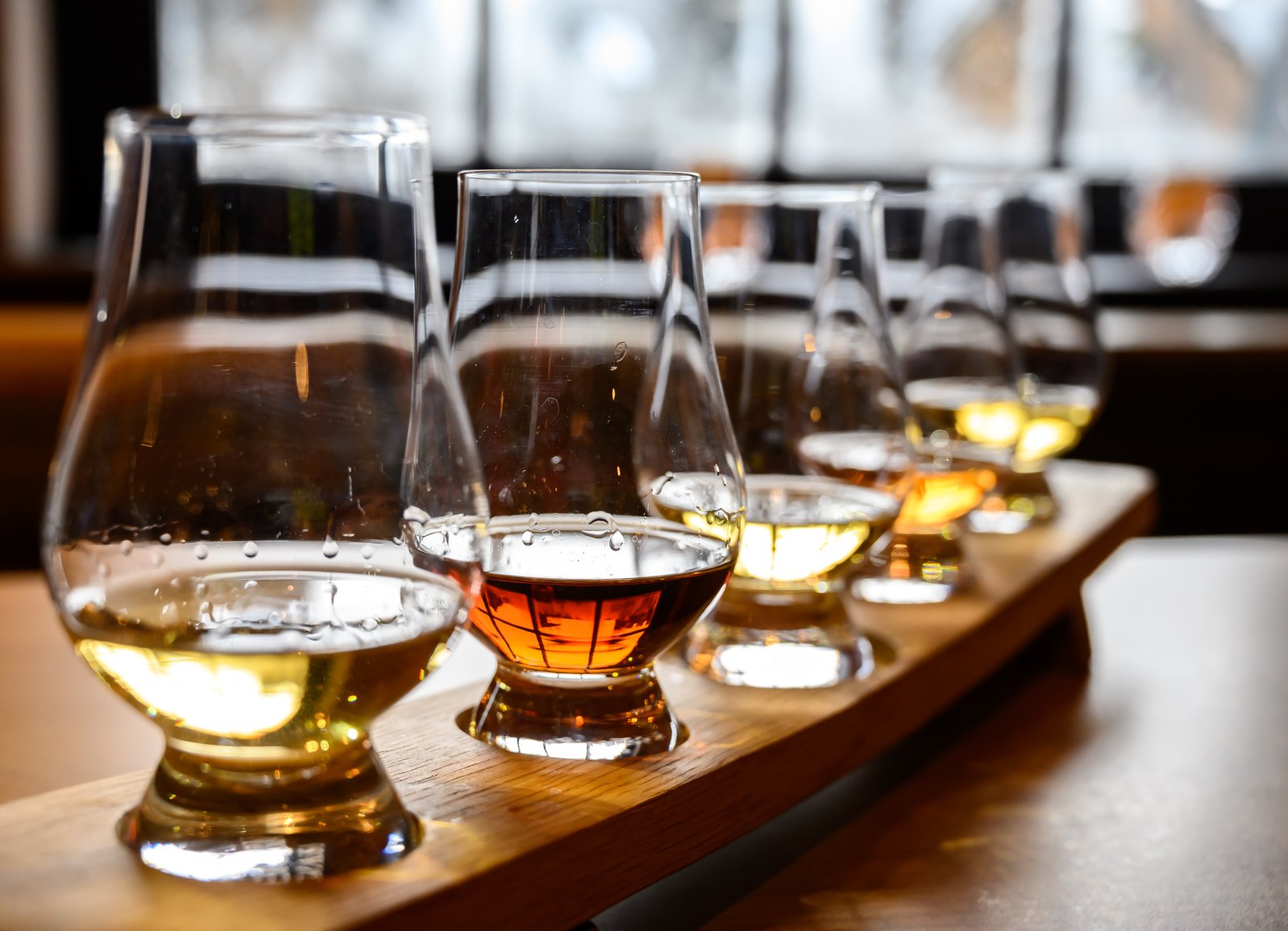 Scotch whisky, tasting glasses with variety of single malts or blended whiskey spirits on distillery tour in Scotland